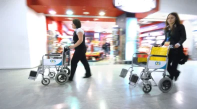 Passenger assistance staff with wheelchairs at Heathrow Airport