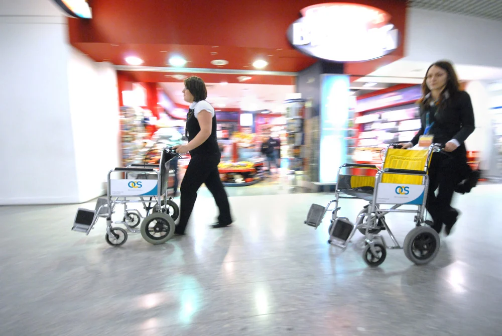 Passenger assistance staff with wheelchairs at Heathrow Airport